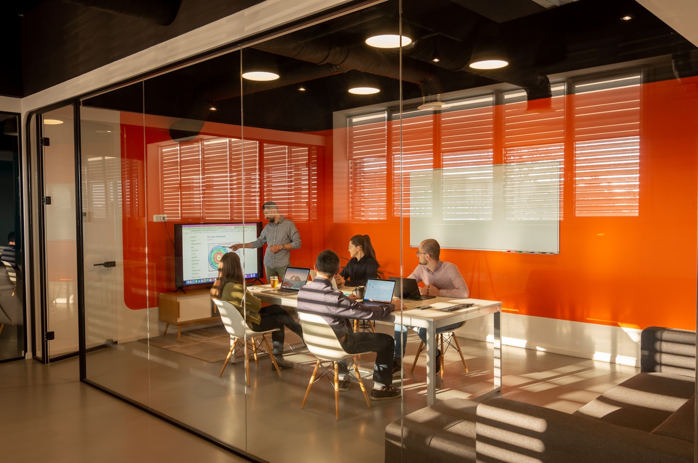 Business team meeting in a modern conference room with a screen.